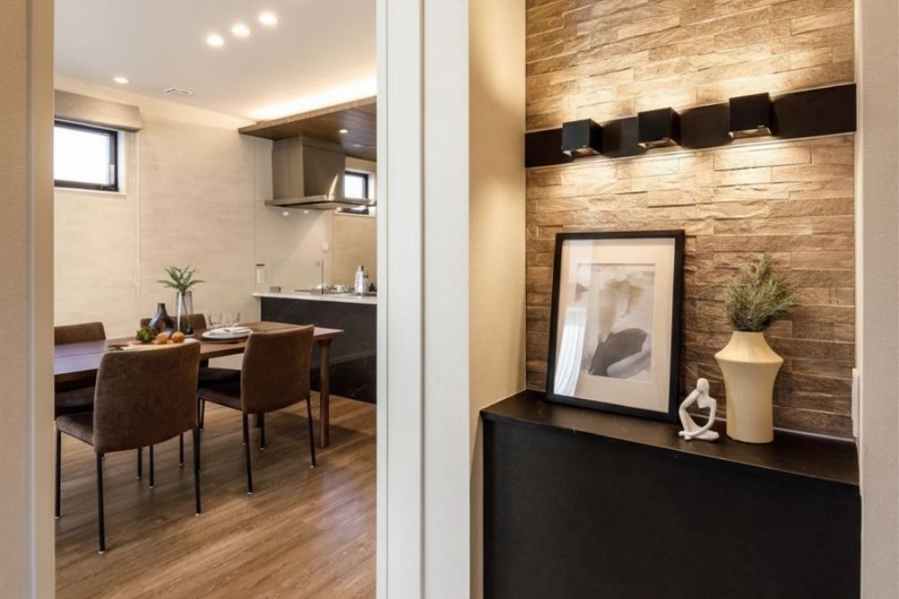 注文住宅の素材選びで個性を出す玄関ホールの石張り壁。間接照明の陰影が美しい質感豊かな住空間。