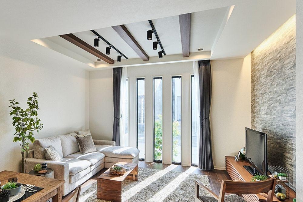 天井埋め込み式のカーテンレールと、縦ラインが美しい大きな窓がある、開放的でモダンなリビングルームの風景。